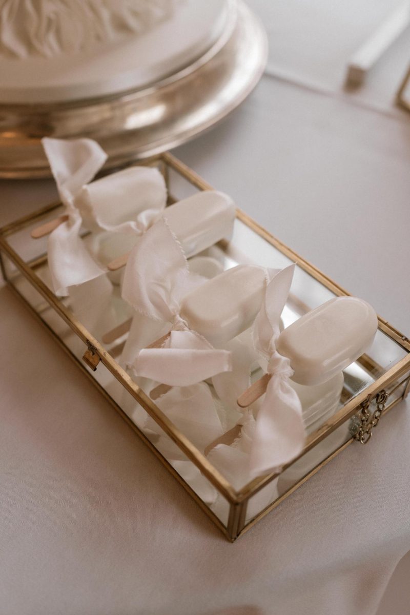 Wedding cake in South Shields. A glass box contains several white popsicles wrapped in white fabric bows.