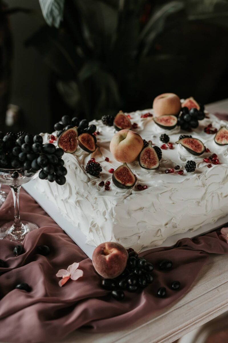 A rectangle wedding cake topped with fresh fruit in a rustic style at Whitworth Hall & Deer Park